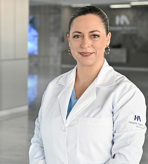 Es la foto de perfil de un ginecólogo y obstetra en Querétaro de Hospital Angeles Centro Sur. Usa una blusa beige con detalles negros y flores pequeñas color rojo. Tiene una coleta.