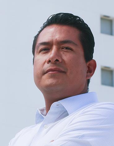 Es la foto de perfil de un cirujano general y cirujano oncológico en Torreón de Hospital Angeles Torreón. Usa una camisa blanca. Tiene el cabello negro. Tiene una ligera sonrisa.