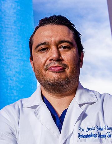 Es la foto de perfil de un gastroenterólogo y endoscopista en Tijuana de Hospital Angeles. Usa una bata blanca con un uniforme médico azul. Tiene el cabello y barba café oscuro