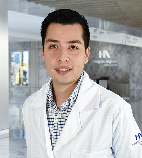 Es la foto de perfil de un endocrinólogo en Querétaro de Hospital Angeles Centro-sur. Usa una bata blanca con una camisa blanca y cuadros con rayas azules. Tiene el cabello color café oscuro.