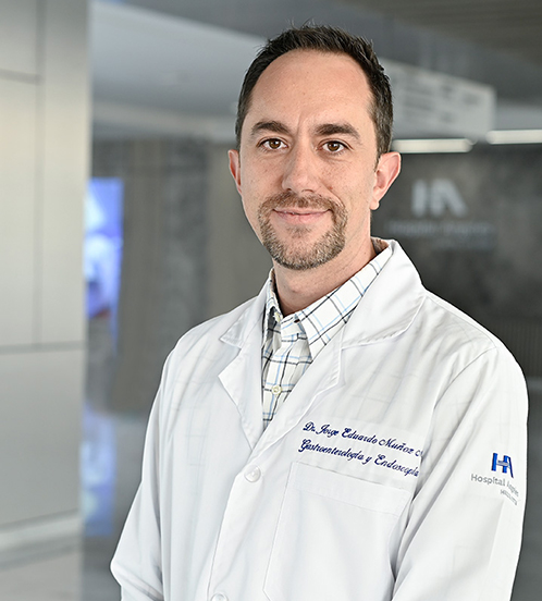 Es la foto de perfil de un internista en Querétaro de Hospital Angeles Centro Sur. Usa un traje de color gris claro con una camisa blanca, tiene barba de candado y está sonriendo.
