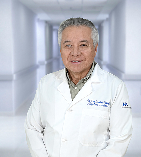 Es la foto de perfil de un alergólogo pediátrico en Ciudad Juárez de Hospital Angeles Ciudad Juárez. El doctor viste una bata blanca, camisa y tiene los brazos cruzados.