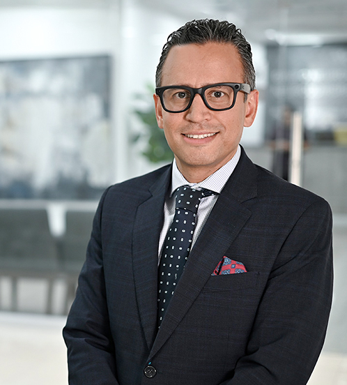 Es la foto de perfil de un cirujano general en Ciudad de México de Hospital Angeles. Viste un traje negro con camisa azul cielo y una corbata naranja claro.