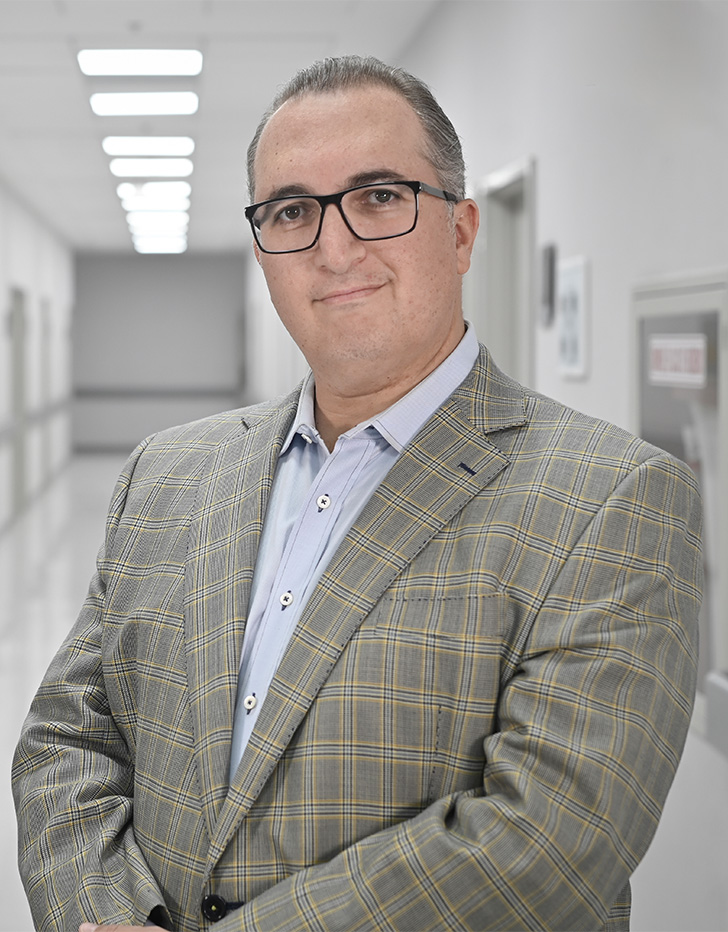 Es la foto de perfil de un cardiólogo y cardiólogo intervencionista en Ciudad de México de Hospital Angeles Universidad. Usa un saco de cuadros con tonalidades verdes y una camisa azul claro. Tiene el cabello gris y usa lentes.