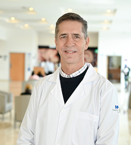 Es la foto de perfil de un ortopedista y traumatólogo en Xalapa de Hospital Angeles Xalapa. Usa un sueter color blanco con una camisa gros y una corbata azul marino. Tiene el cabello café oscuro. Está sonriendo.