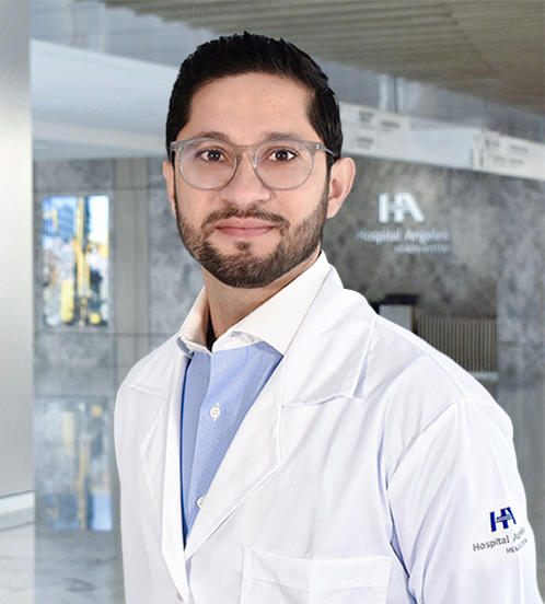 Es la foto de perfil de un cirujano oncológico en Querétaro de Hospital Angeles Centro Sur. Usa un traje gris oscuro y una camisa blanca, tiene barba y está sonriendo.