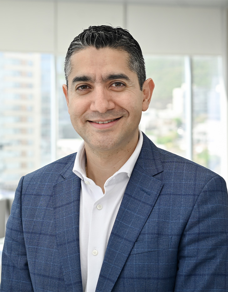 Es la foto de perfil de un pediatra en San Pedro Garza de Hospital Angeles Valle Oriente. Usa un saco color azul marino con una camisa blanca. Tiene el cabello negro y está sonriendo.