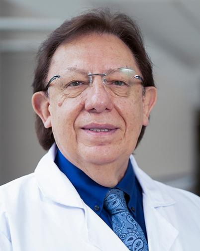 Es la foto de perfil de un oncólogo médico en Huixquilucan de Hospital Angeles Lomas. Usa una bata blanca, con una camisa azul rey y una corbata azul cielo.