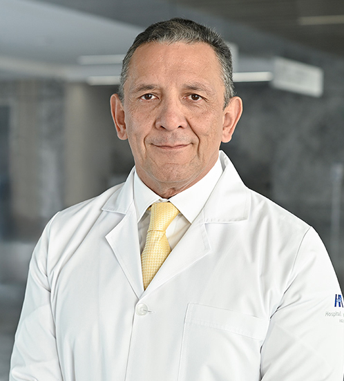 Es la foto de perfil de un ginecólogo y obstetra en Querétaro de Hospital Angeles Centro Sur. Usa un traje azul marino de cuadros con una camisa azul cielo y corbata amarilla.