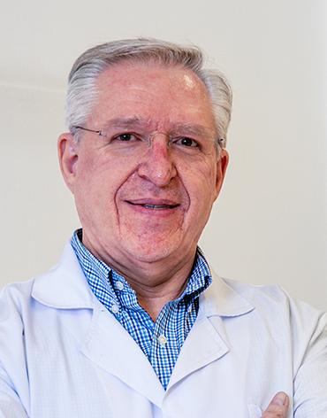 Es la foto de perfil de un endocrinólogo en León de Hospital Angeles León. Utiliza una bata blanca con camisa azul y lineas blancas. Tiene el cabello canoso y lentes.