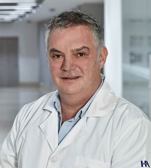 Es la foto de perfil de un ortopedista y traumatólogo en Huixquilucan de Hospital Angeles Lomas. Utiliza una bata blanca, playera negra y es canoso.