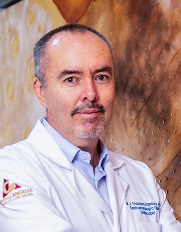 Es la foto de perfil de un gastroenterólogo y endoscopista en León de Hospital Angeles León. Tiene una bata blanca con una camisa azul cielo, tiene barba y bigote. 