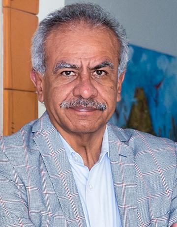 Es la foto de perfil de un angiólogo y cirujano vascular en Xalapa de Hospital Angeles. Usa un saco gros con una camisa blanca. Tiene el cabello y bigote gris.