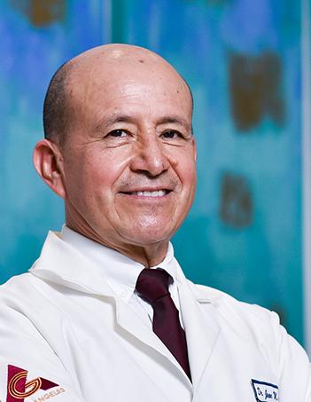 Es la foto de perfil de un cirujano neurológico en Villahermosa de Hospital Angeles. Usa una bata blanca con camisa blanca y una corbata vino.