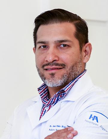 Es la foto de perfil de un pediatra en León de Hospital Angeles León. Utiliza una bata blanca, una camisa de cuadros azul marino con rojo y blanco.