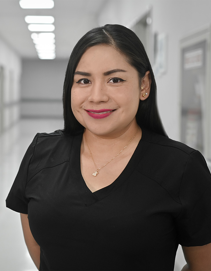 Es la foto de perfil de una angióloga y cirujana vascular y endovascular en Ciudad de México de Hospital Angeles Universidad. Tiene el cabello largo y negro. Usa un uniforme médico negro y labial rojo. Está sonriendo.
