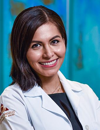 Es la foto de perfil de una ginecóloga en Villahermosa de Hospital Angeles Villahermosa. Usa una bata blanca con una blusa azul marino. Tiene el cabello corto negro. Está sonriendo.