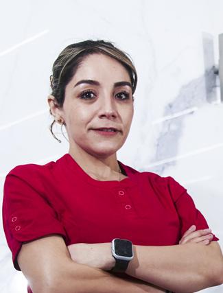 Es la foto de perfil de una oftalmóloga en Ciudad de México de Hospital Angeles Universidad. Usa un uniforme médico rojo. Tiene el cabello café y recogido. Tiene los brazos cruzados y en una muñeca tiene un reloj.