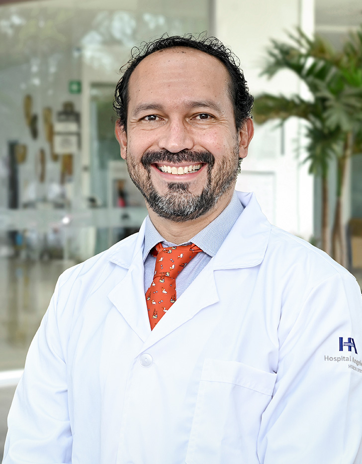Es la foto de perfil de un cirujano general en Ciudad de México de Hospital Angeles. Viste una chamarra azul , tiene barba y está sonriendo.