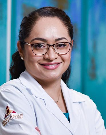 Es la foto de perfil de una pediatra y neumóloga pediátrica en Villahermosa de Hospital Angeles. Usa una bata blanca y una blusa azul cielo. Tiene el cabello recogido, café y tiene lentes.