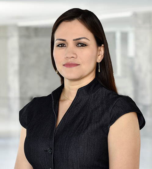 Es la foto de perfil de una especialista en medicina crítica en Querétaro de Hospital Angeles Centro Sur. Usa una camisa negra con botones sin mangas, aretes dorados largos y collar dorado.