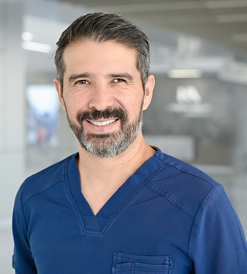 Es la foto de perfil de un urólogo pediátrico y cirujano pediátrico en Querétaro de Hospital Angeles Centro Sur. Usa un uniforme azul marino. Tiene barba y cabello canoso. 