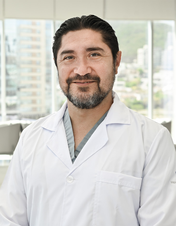 Es la foto de perfil de un coloproctólogo en San Pedro Garza de Hospital Angeles Valle Oriente. Usa una bata blanca. Tiene el cabello y barba negro. Está sonriendo ligeramente.