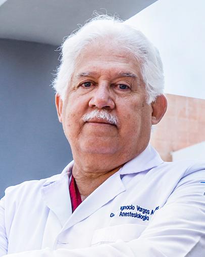 Es la foto de perfil de un anestesiólogo en Guadalajara de Hospital Angeles Del Carmen. Tiene el cabello y el bigote canoso, viste una bata blanca y tiene los brazos cruzados.