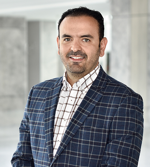 Es la foto de perfil de un cirujano plástico en Querétaro de Hospital Angeles Centro Sur. Usa un traje azul marino y una camisa blanca con cuadros negros.