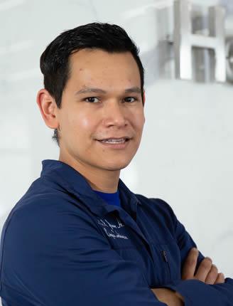 Es la foto de perfil de un cirujano general y cirujano cardiotorácico en Ciudad de México de Hospital Angeles Universidad. Usa una chamarra azul marino. Tiene el cabello negro y los brazos cruzados. Está de perfil y sonriendo.