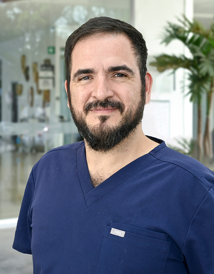 Es la foto de perfil de un ortopedista y traumatólogo en Ciudad de México de Hospital Angeles. Viste un uniforme azul marino, tiene barba y usa lentes.