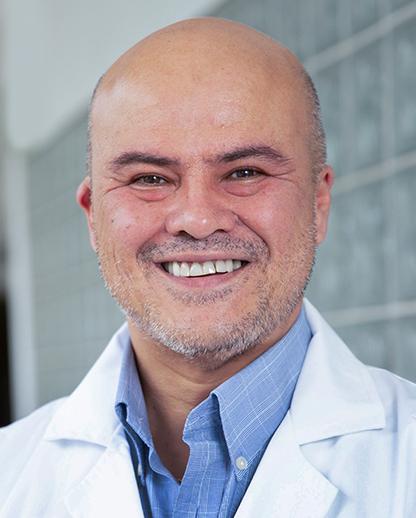 Es la foto de perfil de un ortopedista y traumatólogo en Huixquilucan de Hospital Angeles Lomas. Usa una bata blanca y camisa azul, está sonriendo y es calvo.