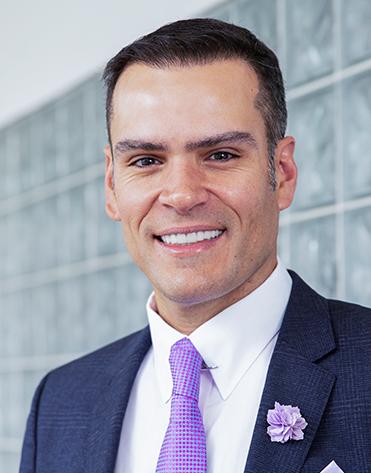 Es la foto de perfil de un cirujano plástico en Huixquilucan de Hospital Angeles Lomas. Usa un saco azul marino, con una camisa blanca y una corbata lila.