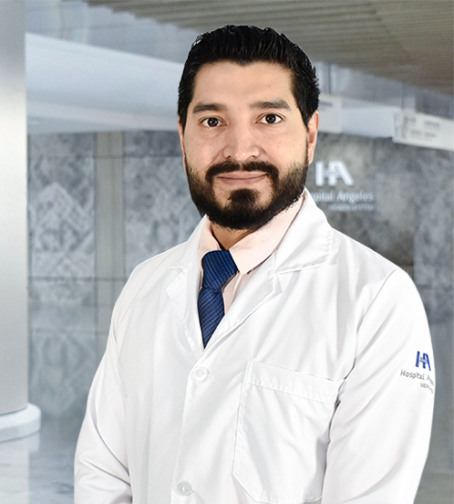 Es la foto de perfil de un cirujano oncológico en Querétaro de Hospital Angeles Centro Sur. Tiene una camisa roja barba y está sonriendo.