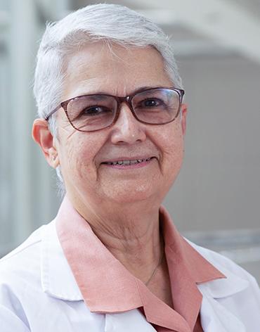 Es la foto de perfil de una psiquiatra en Huixquilucan de Hospital Angeles Lomas. Usa una bata blanca con una camisa color durazno. La doctora tiene el cabello canoso y corto.