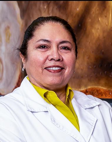 Es la foto de perfil de una neuróloga en León de Hospital Angeles León. La doctora viste una bata blanca con una blusa verde limón, tiene el cabello recogido y está sonriendo.