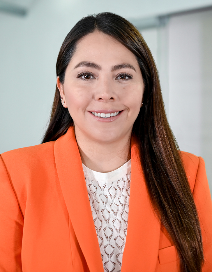 Es la foto de perfil de una nutrióloga en Ciudad de México de Hospital Angeles Santa Mónica. Usa un saco color naranja y una blusa blanca. Tiene el cabello lacio y café oscuro. Está sonriendo.