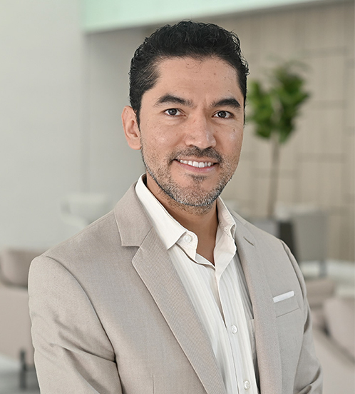 Es la foto de perfil de un neumólogo en Querétaro de Hospital Angeles Centro Sur. El doctor tiene un traje beige camisa blanca barba y está sonriendo.