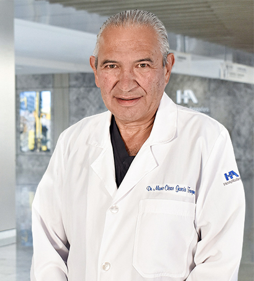 Es la foto de perfil de un especialista en cirugía general y gastrocirugía en Querétaro de Hospital Angeles Centro Sur. El doctor tiene una bata blanca una playera azul marino y cabello peinado hacia atrás. 