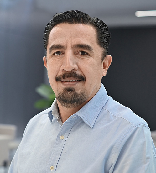 Es la foto de perfil de un oncólogo médico pediátrico en Querétaro de Hospital Angeles Centro Sur. El doctor tiene una camisa azul cielo barba bigote y cabello oscuro.