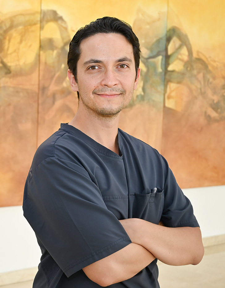 Es la foto de perfil de un urólogo en Ciudad Juárez de Hospital Angeles Ciudad Juárez. Utiliza un uniforme azul marino, está sonriendo.