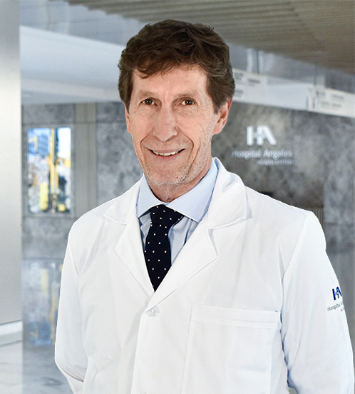 Es la foto de perfil de un cirujano general en Querétaro de Hospital Angeles Centro-sur. Tiene el cabello ondulado y castaño. Usa una bata blanca con una camisa  azul claro y una corbata azul marino con puntos blancos.