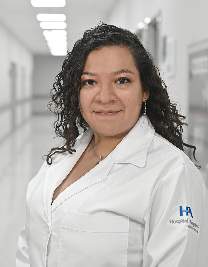 Es la foto de perfil de una cardióloga pediátrica en Ciudad de México de Hospital Angeles Universidad. Usa una bata blanca. Tiene el cabello largo y chino. Está sonriendo ligeremente.