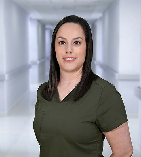 Médica de Hospital Angeles Ciudad Juárez posa sonriendo con un uniforme médico color verde dentro de las instalaciones del hospital.