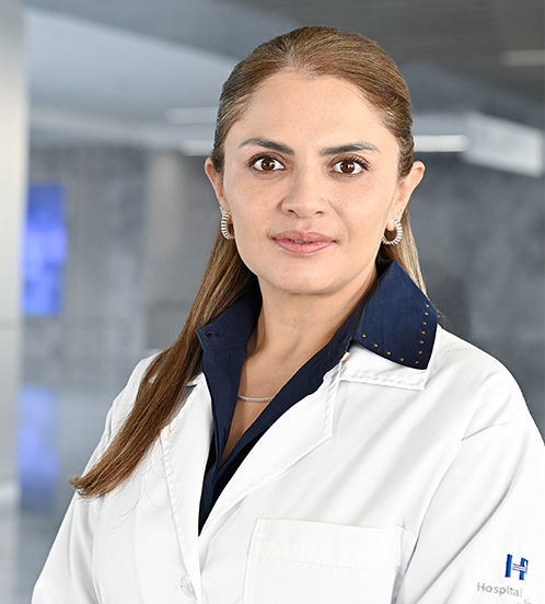 Es la foto de perfil de una psiquiatra en Querétaro de Hospital Angeles Centro Sur. La doctora tiene una bata blanca una blusa con lunares negros aretes largos y cabello largo.