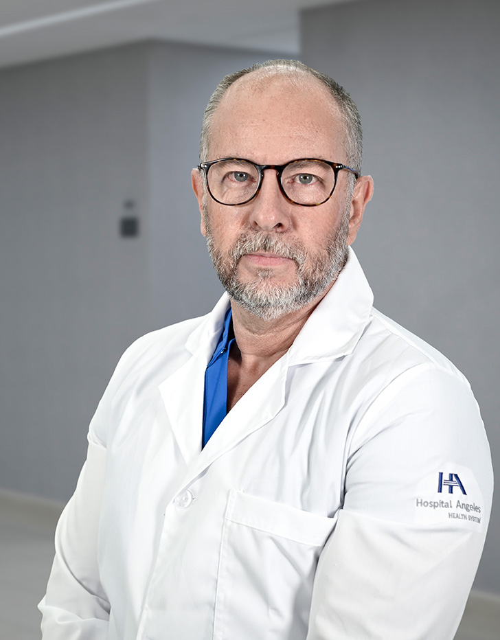 Es la foto de perfil de un ortopedista y traumatólogo en Ciudad de México de Hospital Angeles Lindavista. Tiene barba gris. Usa un uniforme médico color verde.