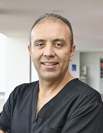 Es la foto de perfil de un pediatra en León de Hospital Angeles León. Usa un uniforme negro con cuello V. 