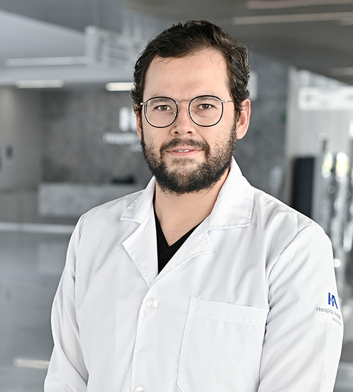 Es la foto de perfil de un pediatra en Querétaro de Hospital Angeles Centro Sur. El doctor tiene la camisa de rayas blancas con gris y usa lentes.