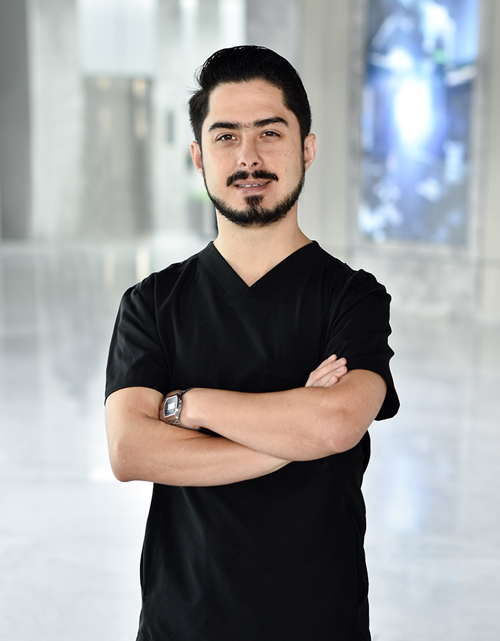 Es la foto de perfil de un pediatra en Querétaro de Hospital Angeles Centro Sur. El doctor usa un uniforme negro con cuello v tiene los brazos cruzados y usa Barba.