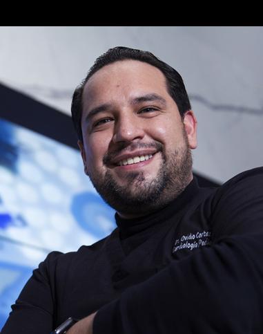 Es la foto de perfil de un especialista en electrofisiología, cardiólogo pediátrico y pediatra en Ciudad de México de Hospital Angeles Universidad. Usa una camisa negra. Tiene el cabello y barba negra. Tiene los brazos cruzados y está sonriendo.
